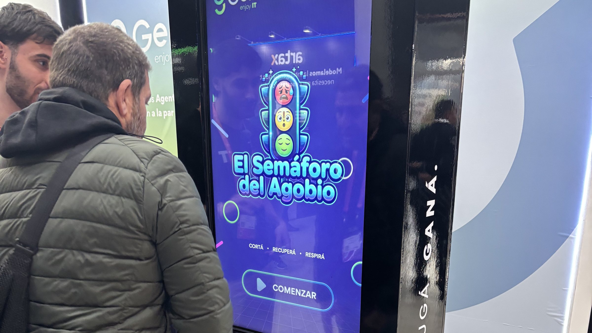 Asistente de AILAT26 frente al tótem touch de GEN IT con El Semáforo del Agobio
