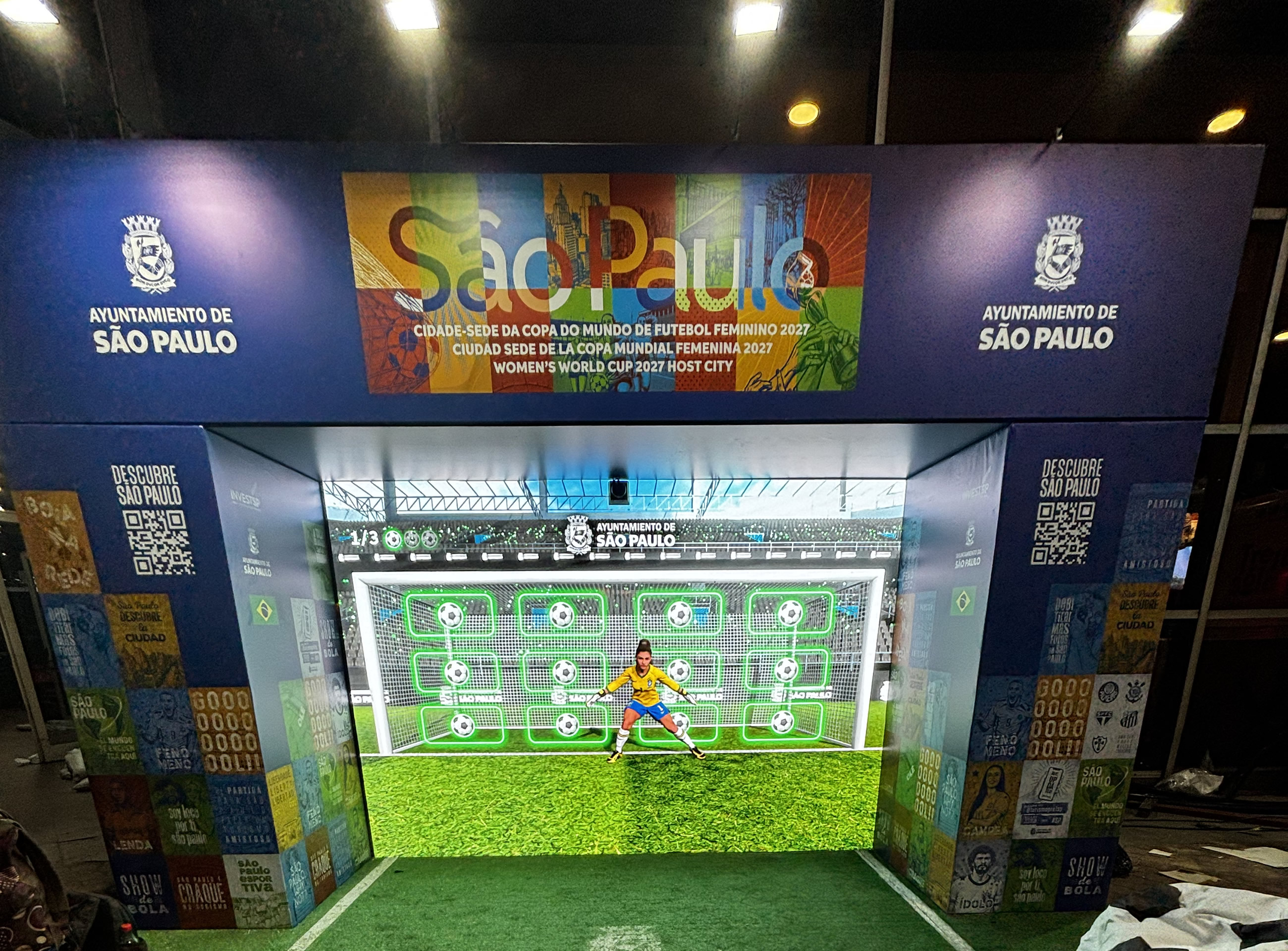Stand del Ayuntamiento de São Paulo en la FIT 2026: arco con pantalla LED y arquera virtual de Soy Goleador